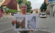 Das Bild zeigt eine Stadführerin, die Bilder zeigt auf denen zu sehen ist, wie die Geiselbachstraße früher ausgesehen hat. Das Bild zeigt eine Stadführerin, die Bilder zeigt auf denen zu sehen ist, wie die Geiselbachstraße früher ausgesehen hat.